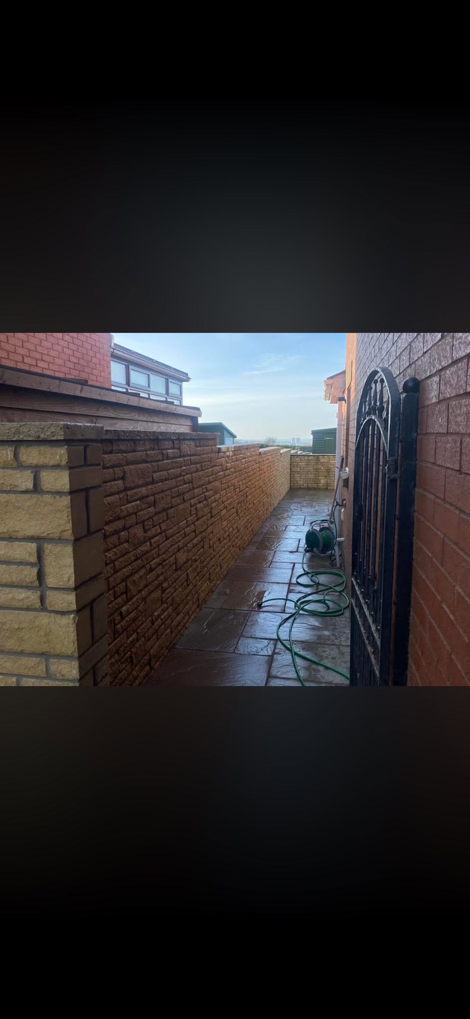 Natural faced stone boundary wall and wrought iron gate in St Bees